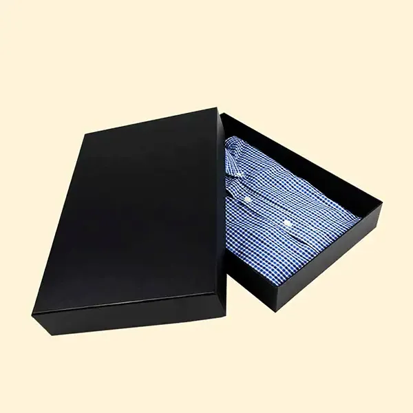 A black box containing a neatly folded blue shirt inside.